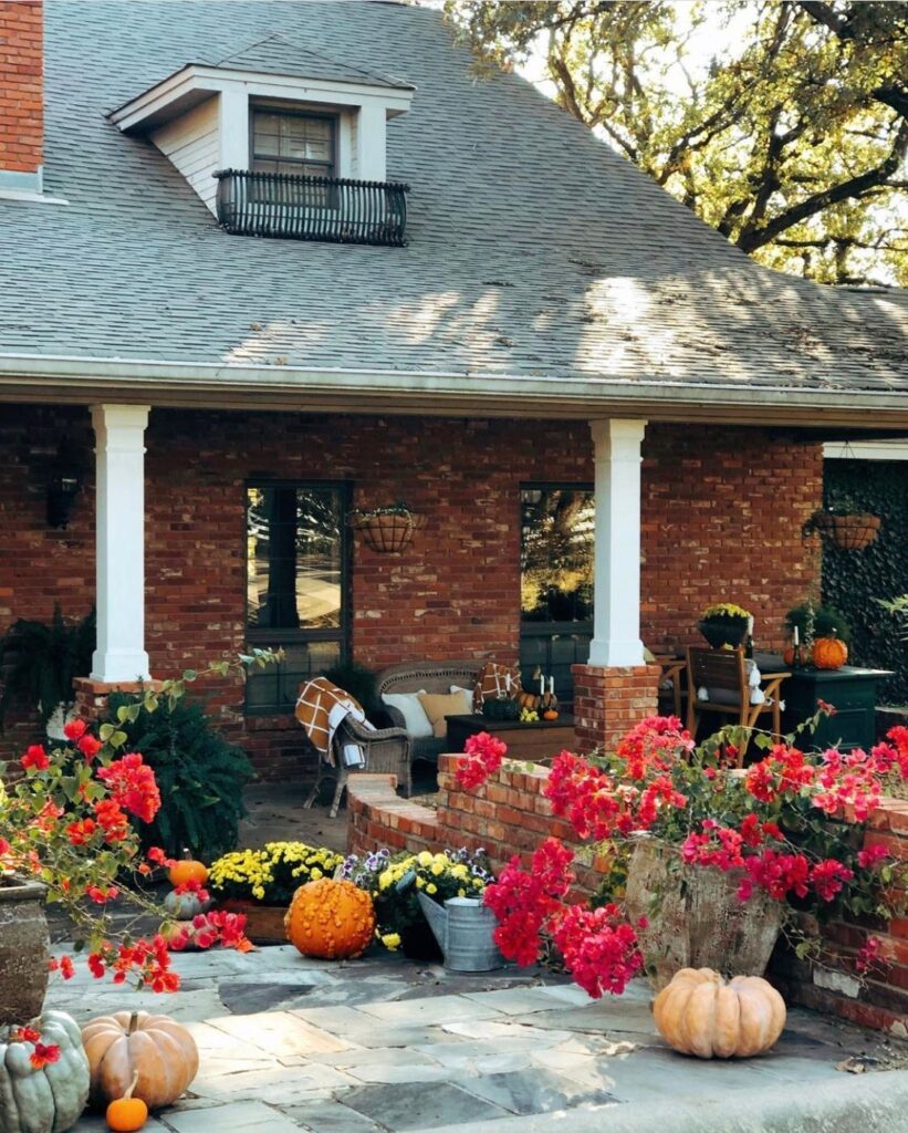 Large country porch with flowers and pumpkins