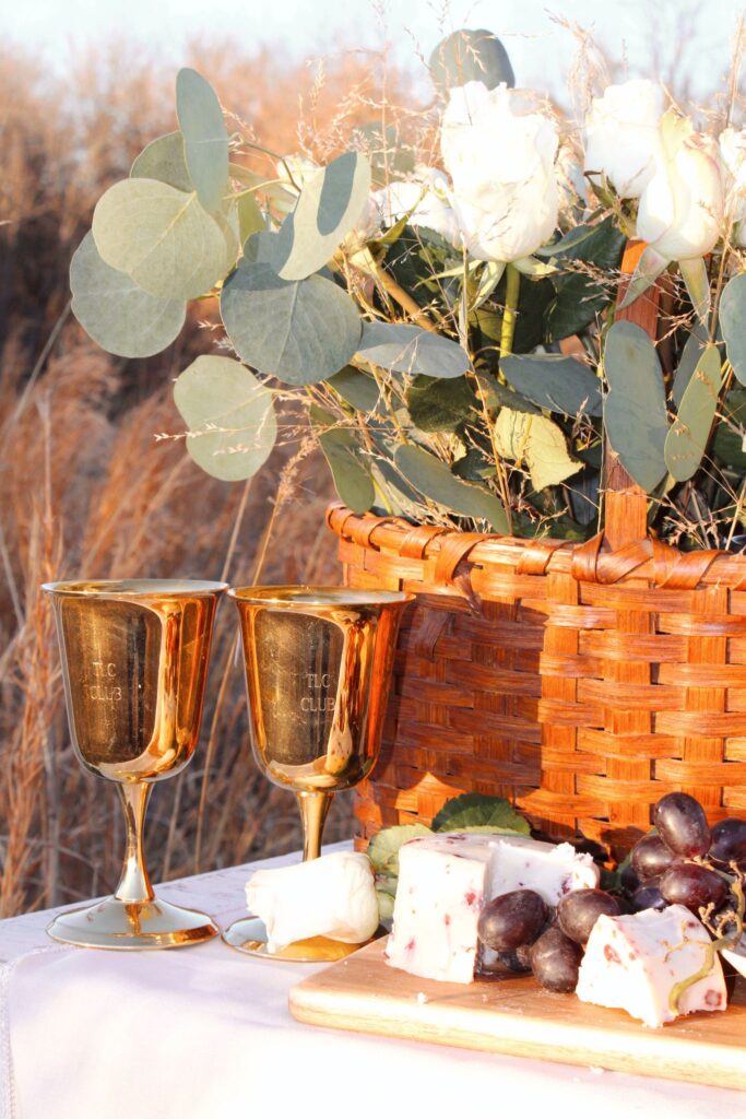 Gold goblets, flowers cheese and grapes.