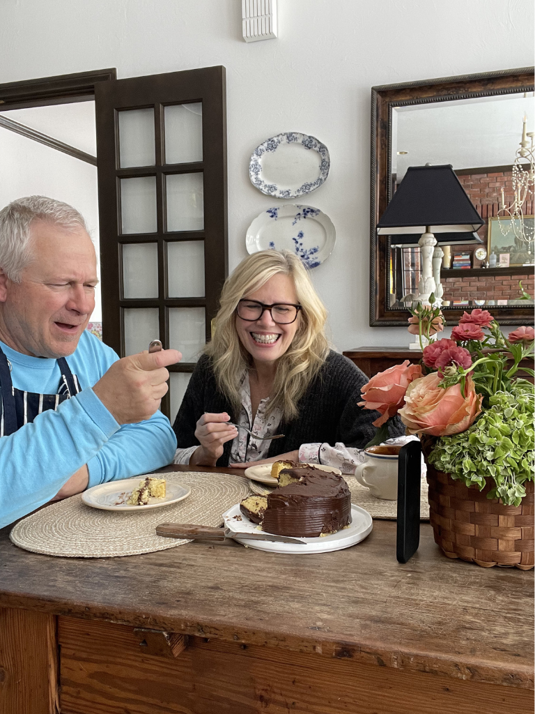 A retired couple celebrating a birthday with chocolate cake in a vintage inspired country home